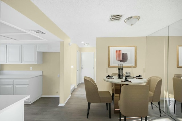 dining area with dark hardwood / wood-style flooring and a textured ceiling