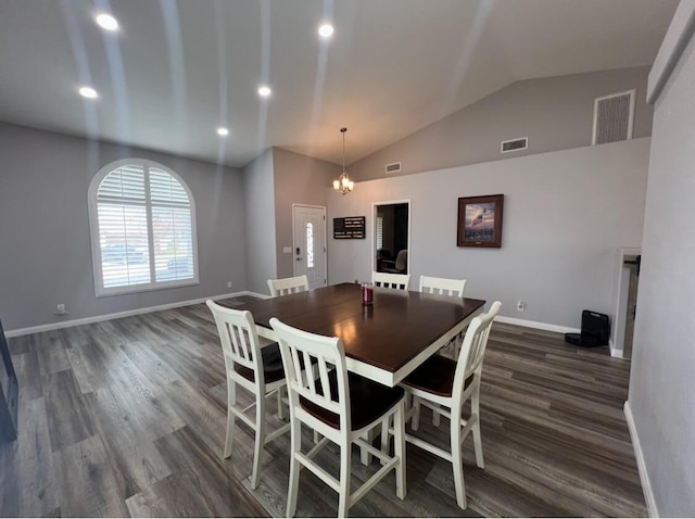 dining room with dark hardwood / wood-style flooring, lofted ceiling, and an inviting chandelier