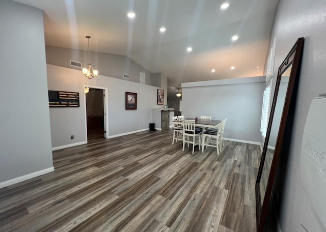 dining area with dark hardwood / wood-style floors, a chandelier, and lofted ceiling