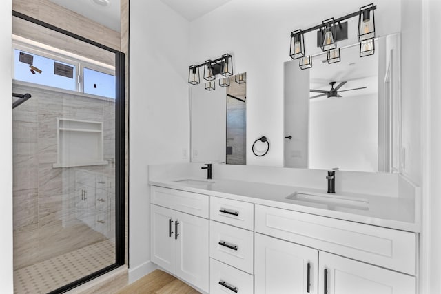 full bath with ceiling fan, a sink, a shower stall, and double vanity