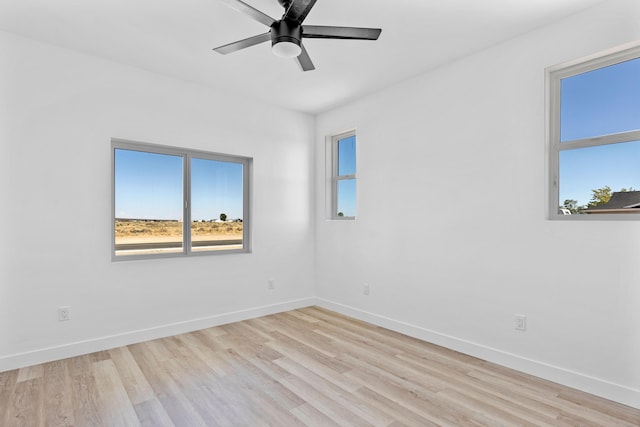 empty room with a ceiling fan, baseboards, and wood finished floors