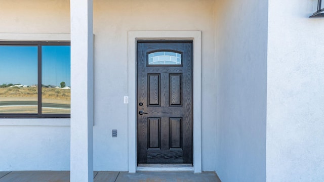 doorway to property featuring stucco siding