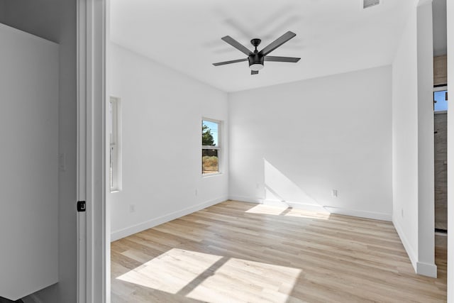 unfurnished room featuring light wood-style flooring, visible vents, baseboards, and ceiling fan