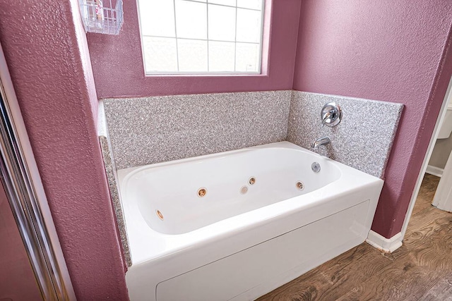 bathroom with hardwood / wood-style floors and a bathtub