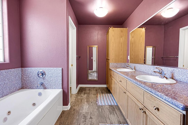 bathroom with hardwood / wood-style floors, vanity, and a bath