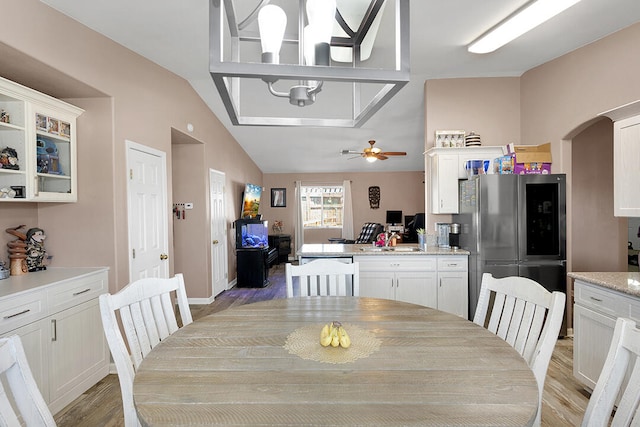 dining area with ceiling fan, light hardwood / wood-style flooring, lofted ceiling, and sink