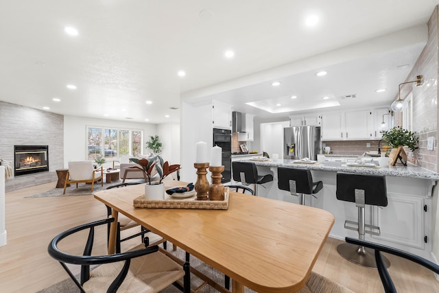 41901 Cll Clarita, Lancaster, CA 93536 - dining area featuring a large fireplace, light wood finished floors, and recessed lighting