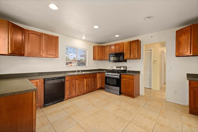 kitchen with light tile patterned flooring, sink, and black appliances