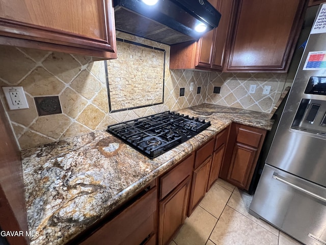 2812 Crocus Pl, Palmdale, CA 93551 - kitchen with black gas cooktop, wall chimney exhaust hood, stainless steel fridge, dark stone counters, and tasteful backsplash