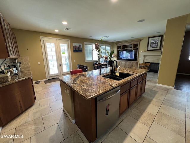 2812 Crocus Pl, Palmdale, CA 93551 - kitchen featuring stainless steel dishwasher, a fireplace, a center island with sink, open floor plan, and dark stone countertops