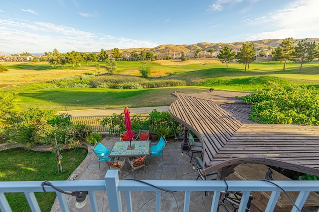 view of community featuring a mountain view, a patio area, and a lawn