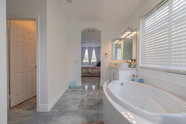 bathroom with vanity and a relaxing tiled tub