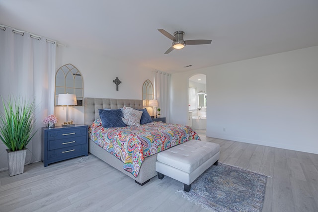 bedroom featuring ensuite bath, ceiling fan, and light wood-type flooring