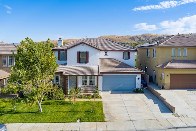 mediterranean / spanish-style home featuring a mountain view, a front lawn, and a garage