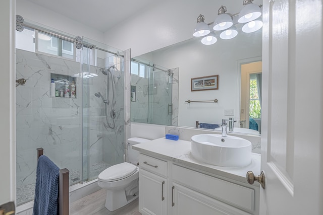 bathroom with hardwood / wood-style floors, vanity, toilet, and an enclosed shower