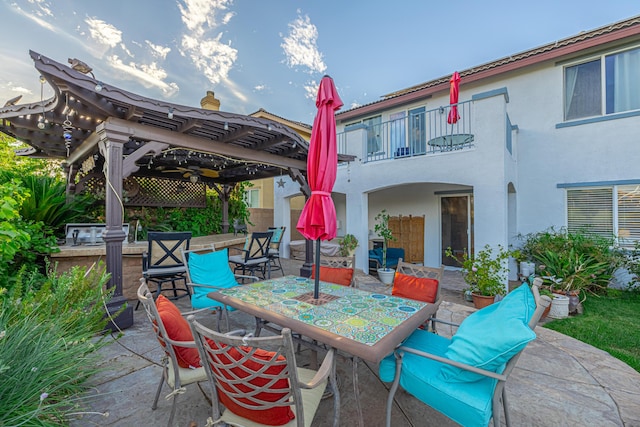 view of patio with a pergola and a balcony