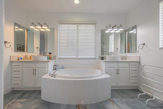 bathroom with vanity and tiled tub