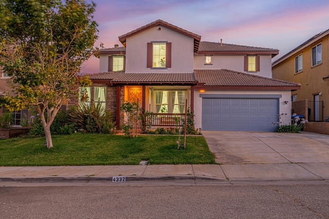 mediterranean / spanish-style house featuring a garage and a yard