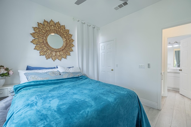 bedroom featuring ceiling fan, ensuite bathroom, and light hardwood / wood-style floors