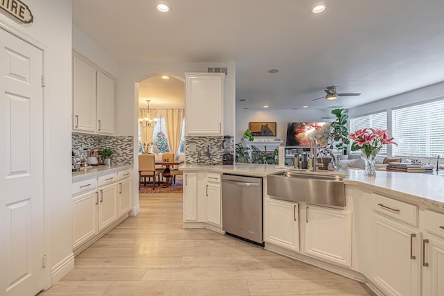 kitchen with ceiling fan with notable chandelier, white cabinetry, stainless steel dishwasher, and sink