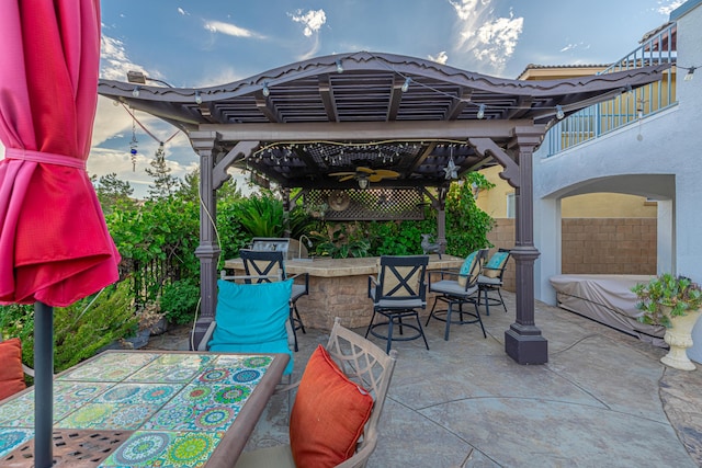 view of patio / terrace featuring exterior bar, a pergola, a balcony, and ceiling fan