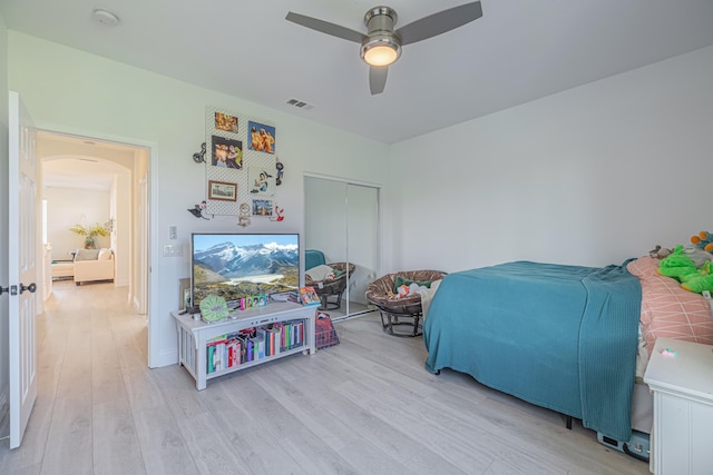 bedroom featuring ceiling fan, a closet, and light wood-type flooring