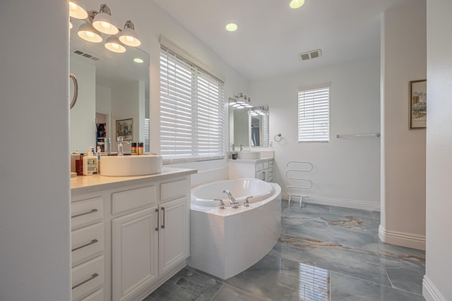 bathroom featuring tiled bath and vanity