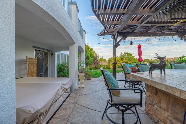 view of patio / terrace with exterior bar and a pergola