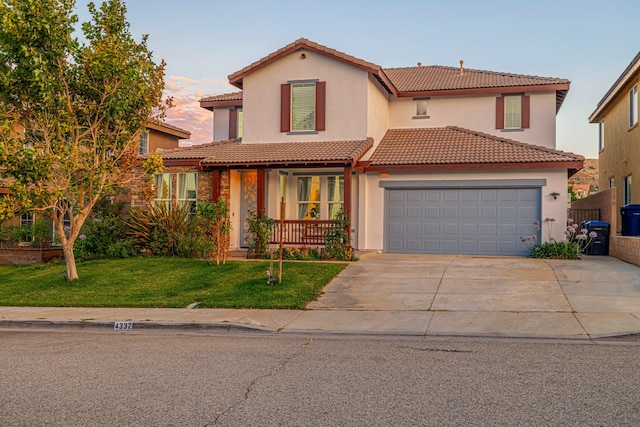 mediterranean / spanish-style home featuring a front yard and a garage