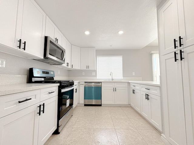 kitchen with white cabinetry, light tile patterned floors, a textured ceiling, and appliances with stainless steel finishes