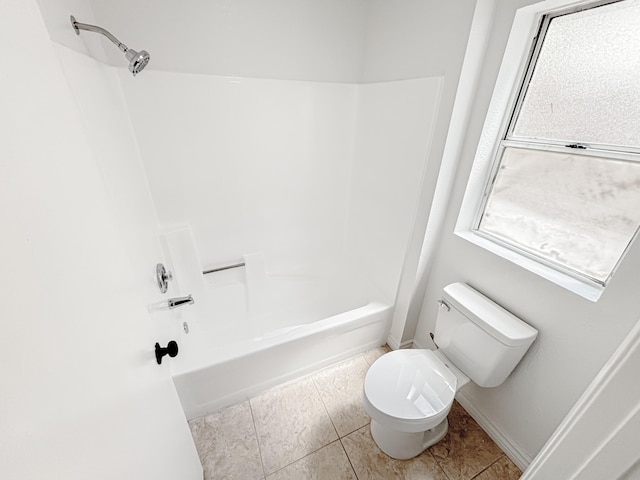 bathroom featuring tile patterned floors, toilet, and washtub / shower combination