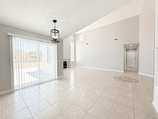 interior space featuring a notable chandelier, light tile patterned floors, and vaulted ceiling