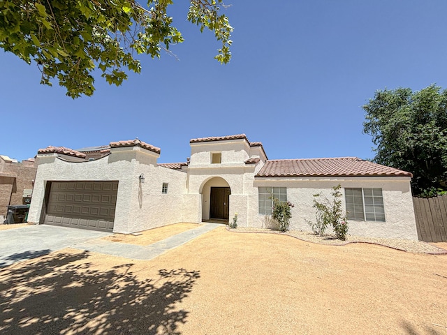 mediterranean / spanish-style home with a garage