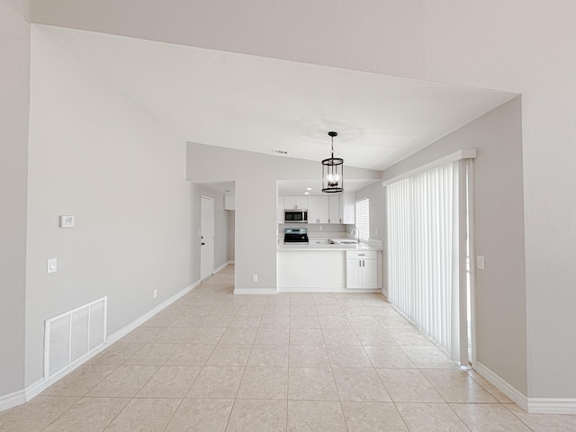 unfurnished living room with sink, light tile patterned floors, a chandelier, and lofted ceiling