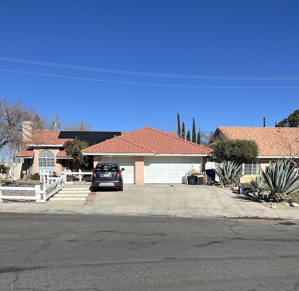 view of front facade with solar panels and a garage