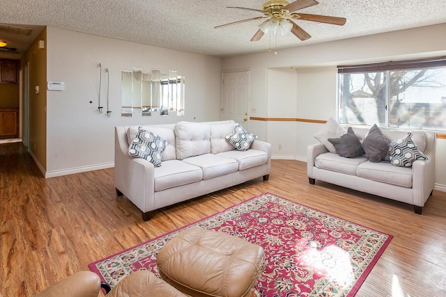 living room with a textured ceiling, ceiling fan, plenty of natural light, and hardwood / wood-style floors