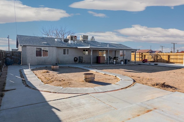 back of house with cooling unit, an outdoor fire pit, and a patio