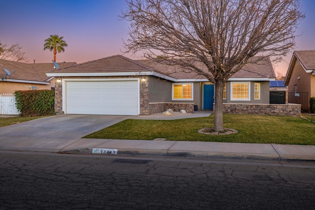 view of front of home with a garage and a lawn