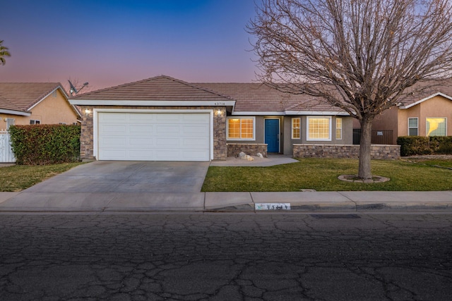 ranch-style house featuring a lawn and a garage