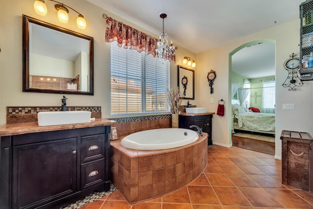 bathroom with vanity, tile patterned floors, a relaxing tiled tub, and tasteful backsplash