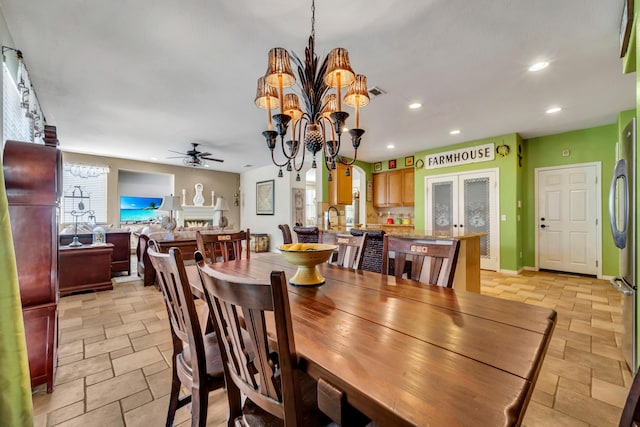 dining room with ceiling fan with notable chandelier