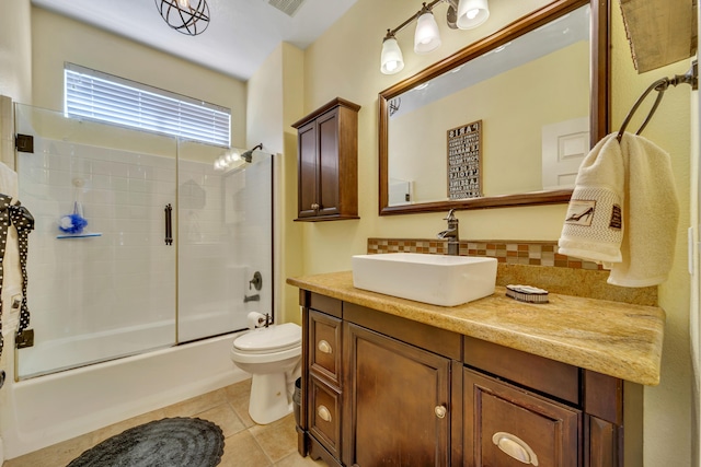 full bathroom featuring shower / bath combination with glass door, vanity, toilet, and tile patterned flooring