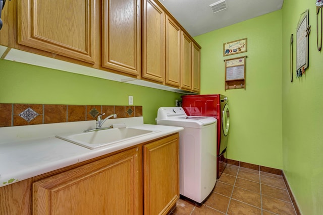 laundry area featuring cabinets, sink, tile patterned floors, and separate washer and dryer