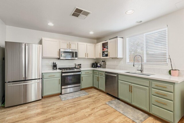 40305 Reata Rd, Palmdale, CA 93550 - kitchen with green cabinets, appliances with stainless steel finishes, a sink, light countertops, and recessed lighting