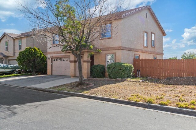 40305 Reata Rd, Palmdale, CA 93550 - view of front facade with fence, driveway, stucco siding, and an attached garage