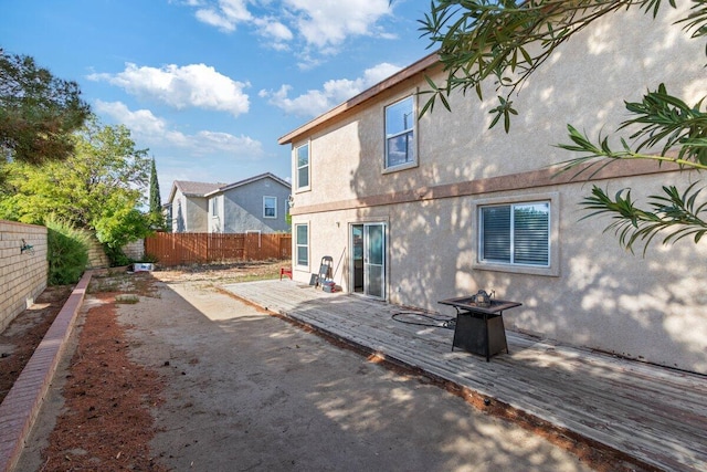 40305 Reata Rd, Palmdale, CA 93550 - rear view of property featuring stucco siding, a fenced backyard, a fire pit, and a deck