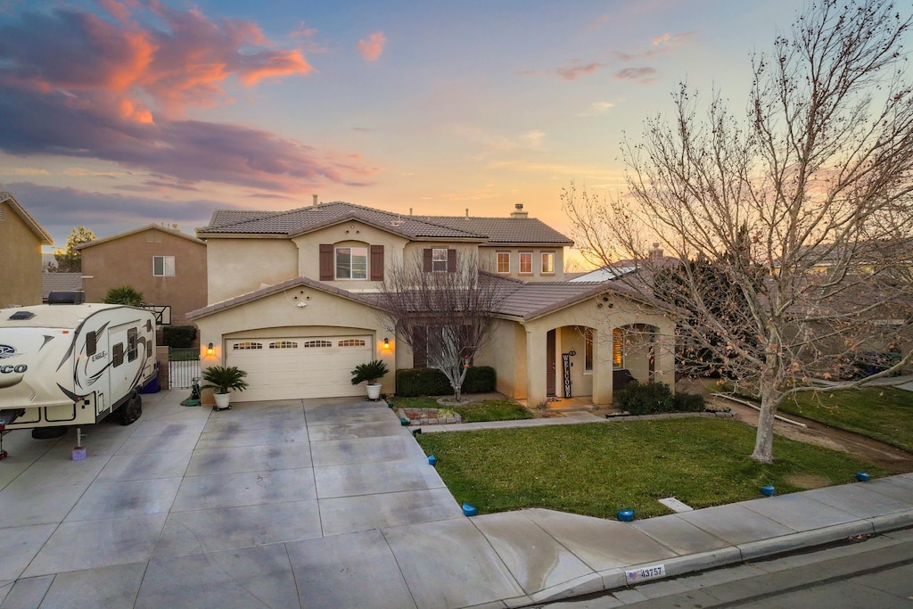 mediterranean / spanish-style home featuring a yard and a garage