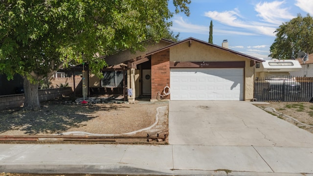 view of front of home featuring brick siding, fence, concrete driveway, stucco siding, and an attached garage