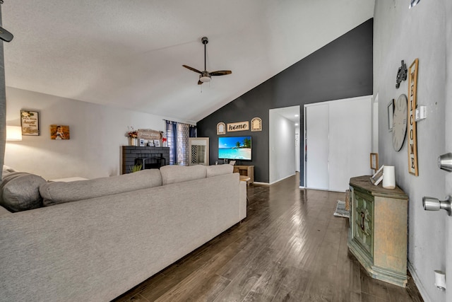 living room with dark wood-type flooring, baseboards, a fireplace, high vaulted ceiling, and a ceiling fan