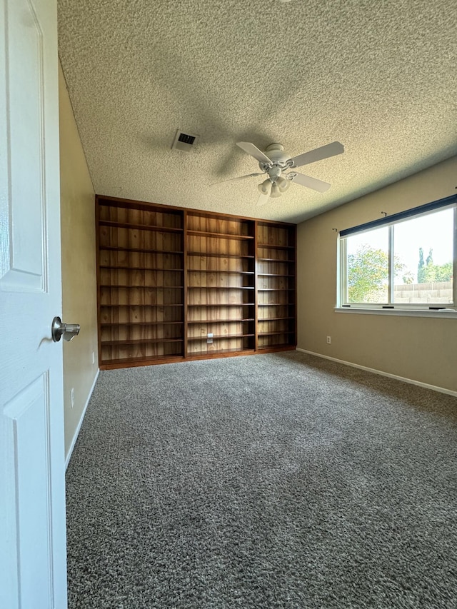 empty room with carpet flooring, visible vents, and baseboards